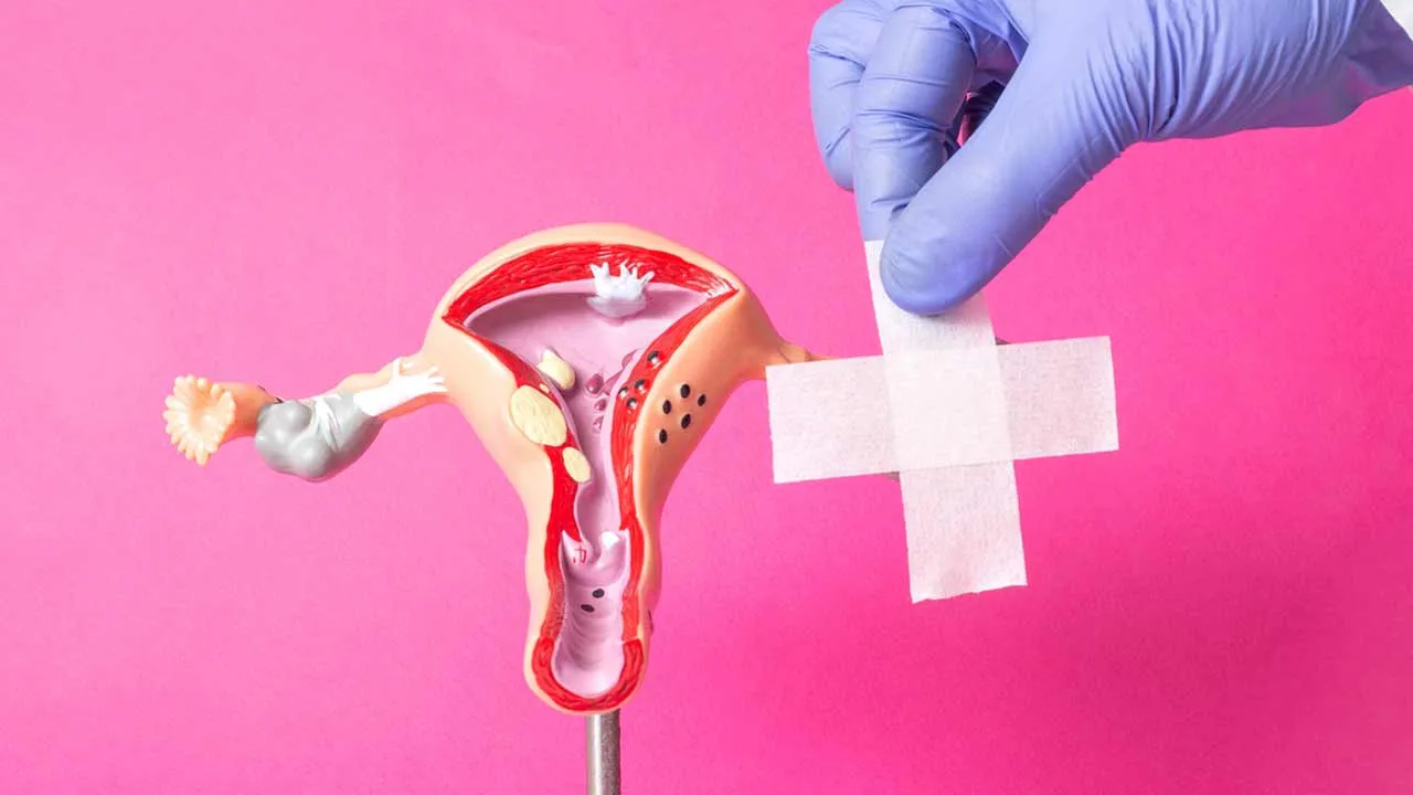 Woman holding her stomach in discomfort while looking at a calendar