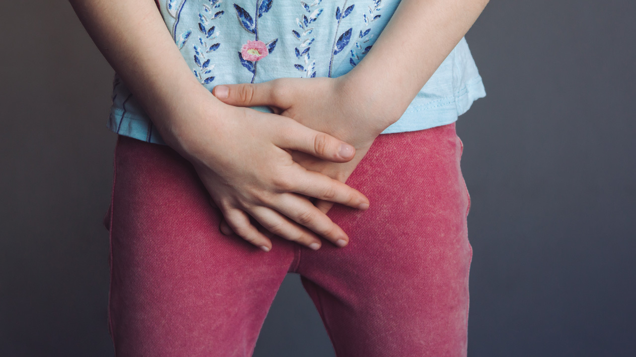 Kid Holding Lower Abdomen With Mild Discomfort Expression