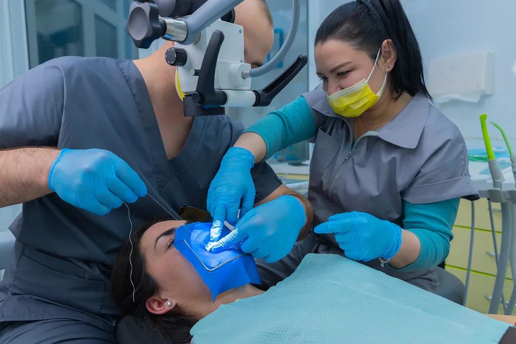Man holding an Invisalign® aligner and a model of traditional braces.