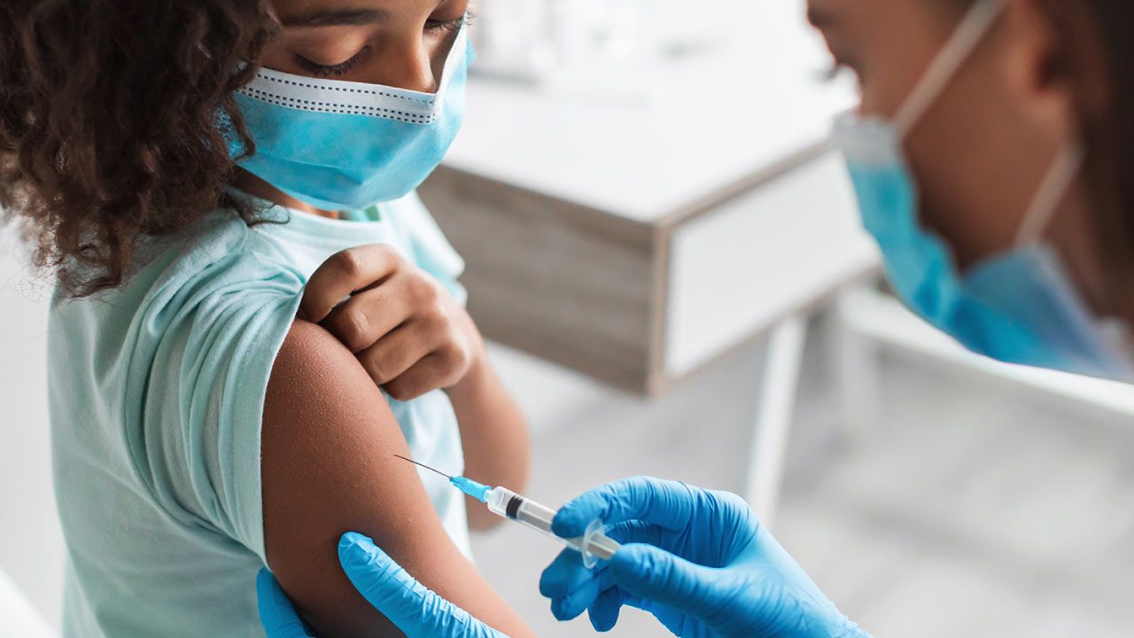 Parent helping child wash hands during flu season for infection prevention