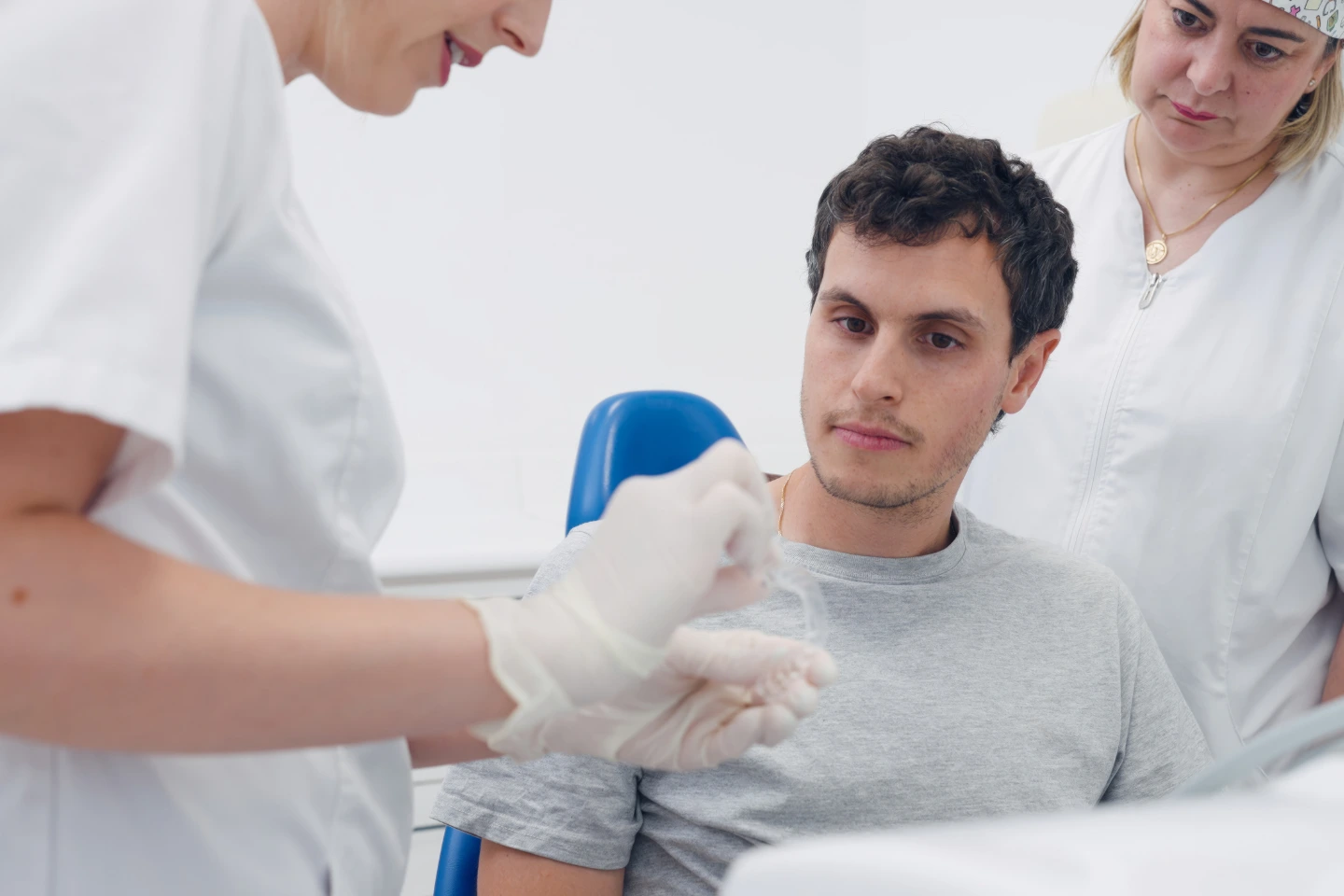 Patient consulting dentist about Invisalign clear aligners during orthodontic treatment visit