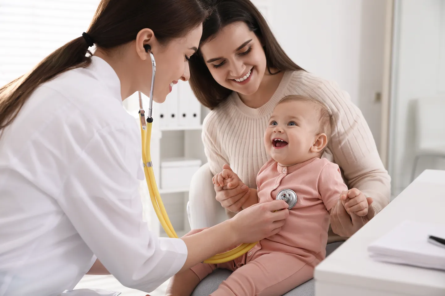 Pediatrician examining a child’s ear for infection with an otoscope