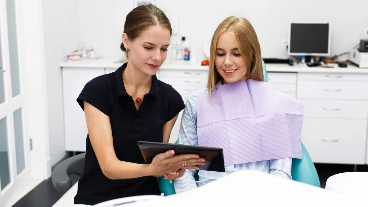 Dr explaining orthodontic treatment options, including braces and clear aligners, to a patient during a consultation.