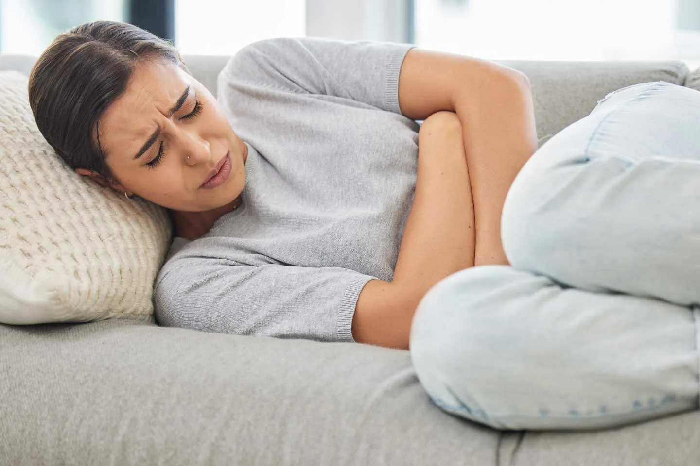 Pregnant woman experiencing abdominal pain while consulting a gynecologist about an ectopic pregnancy