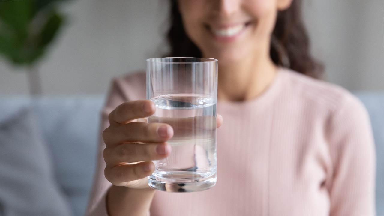 Glass of water with kidney illustration in the background