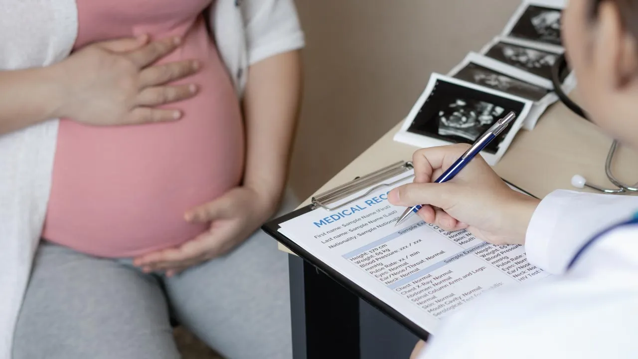 Obstetrician counseling a pregnant woman about Rh incompatibility during a prenatal visit