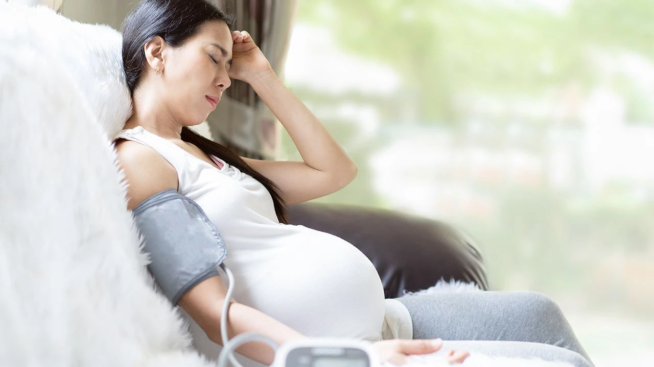 Pregnant woman with blood pressure cuff.