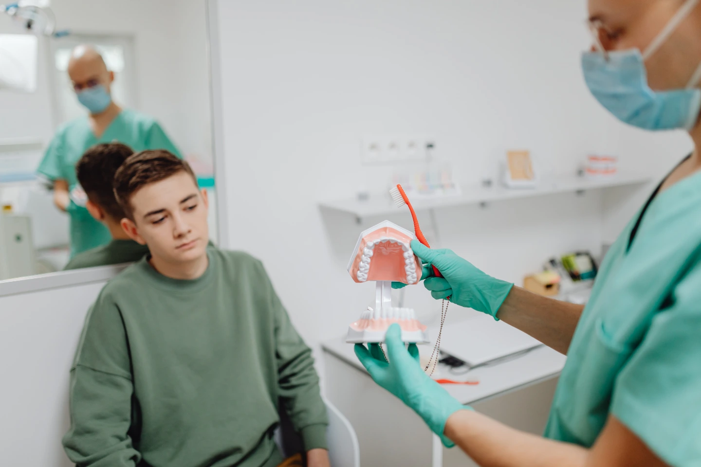 Pediatric dentist demonstrating brushing technique to child—supports dental anxiety education and gentle care in Springfield MA.