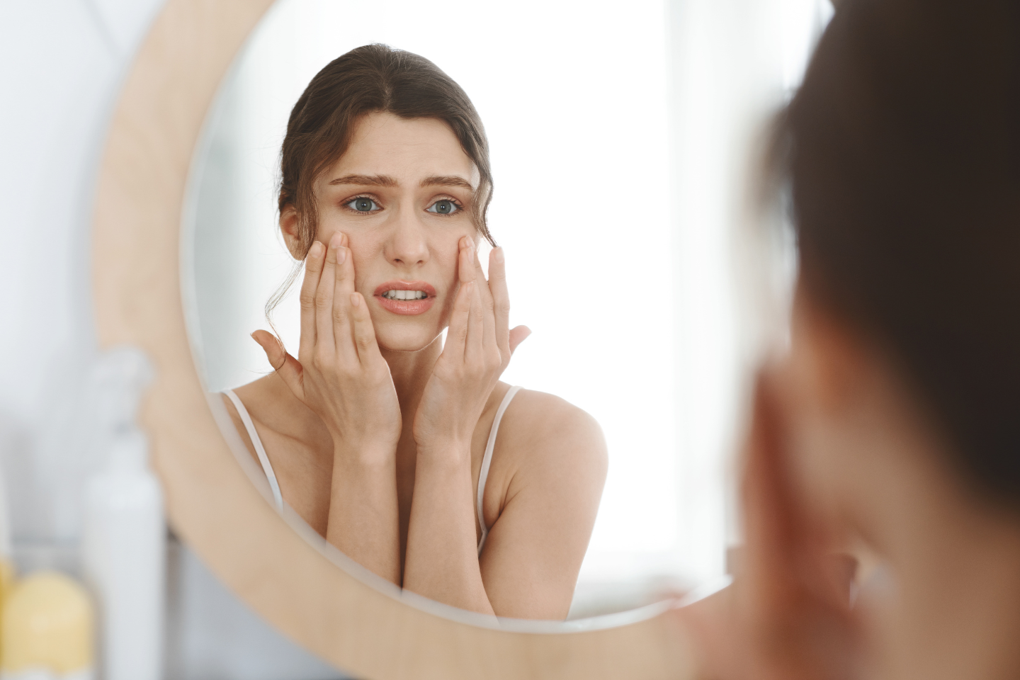 Icon of a face with stress lines and small spots symbolizing breakouts.