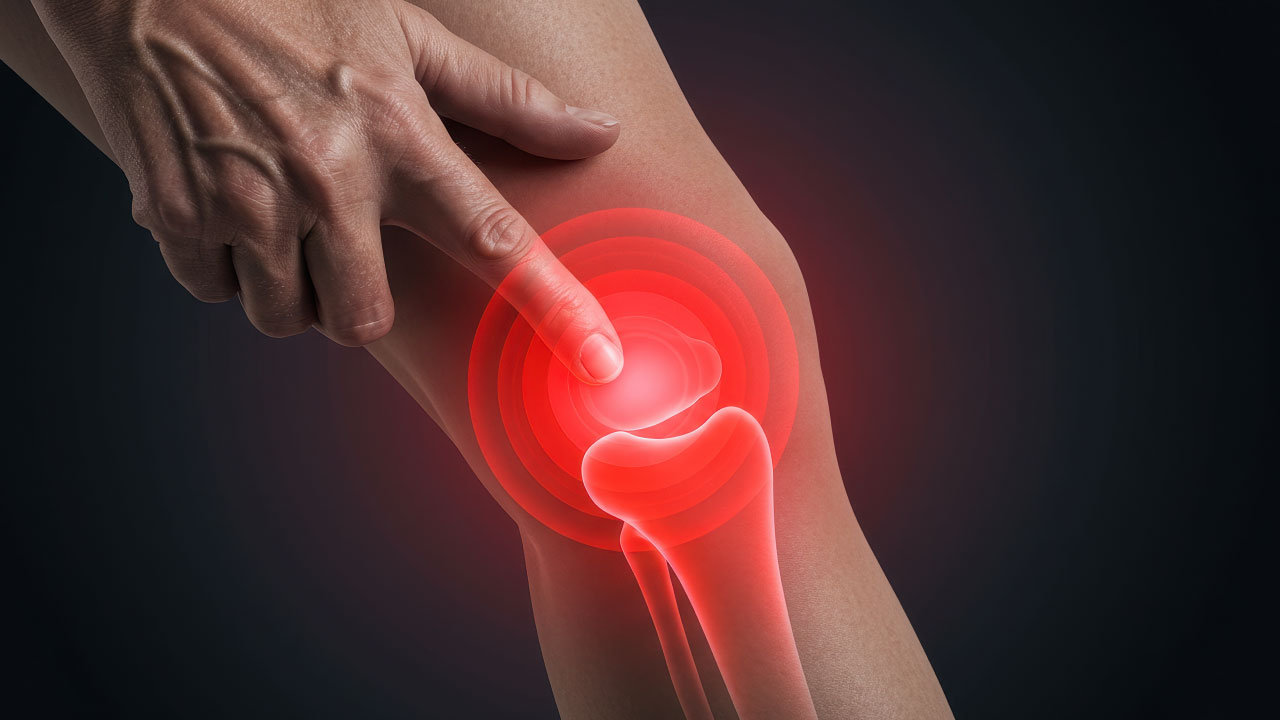 Person holding their knee with a worried expression indicating joint pain
