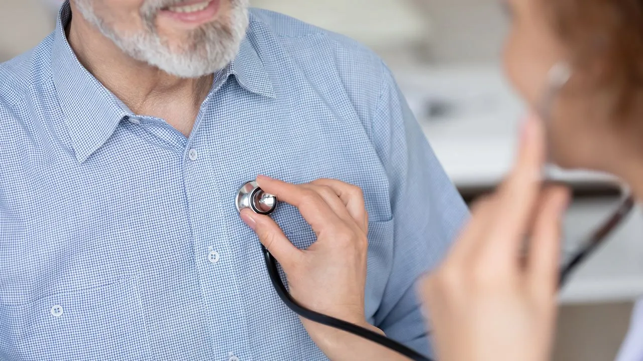 Cardiologist explaining coronary artery blockage and heart disease warning signs to a patient